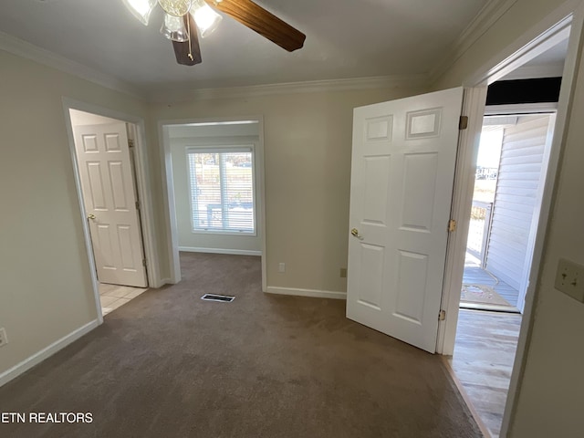 empty room featuring light colored carpet, ceiling fan, and crown molding