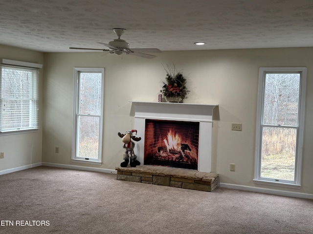 unfurnished living room featuring a healthy amount of sunlight and a stone fireplace