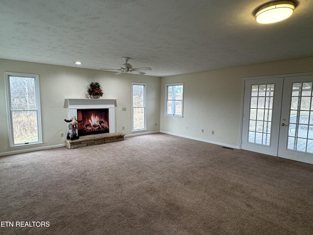 unfurnished living room with carpet flooring, ceiling fan, and a wealth of natural light