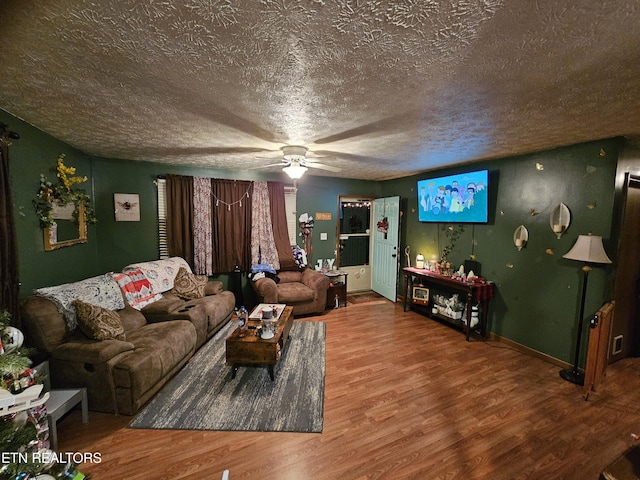 living room with ceiling fan, a textured ceiling, and hardwood / wood-style flooring