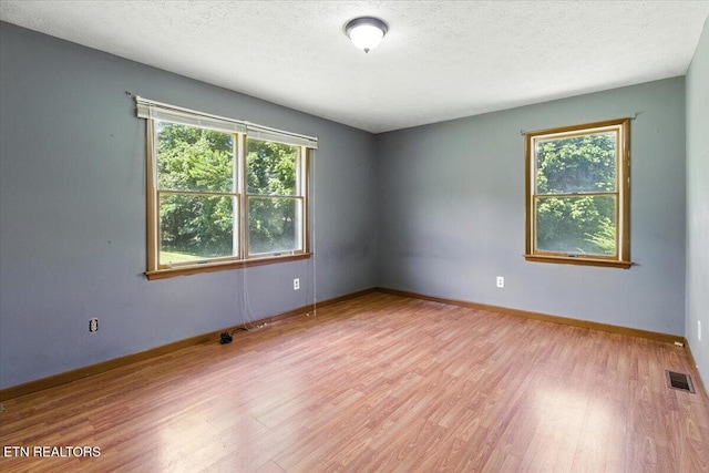 505 S S 38th St, Middlesboro, KY 40965 - unfurnished room with light wood-style flooring, healthy amount of natural light, and a textured ceiling