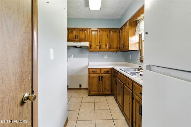 505 S S 38th St, Middlesboro, KY 40965 - kitchen featuring freestanding refrigerator, under cabinet range hood, brown cabinets, and light countertops