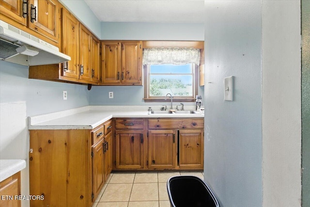 505 S S 38th St, Middlesboro, KY 40965 - kitchen featuring under cabinet range hood, brown cabinets, light countertops, and light tile patterned floors