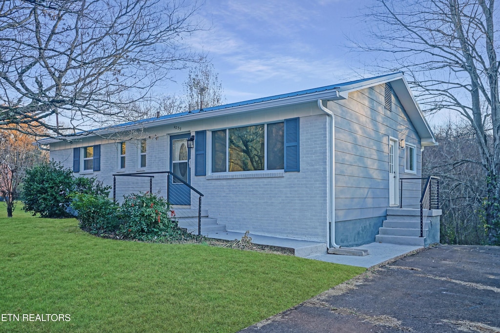 single story home featuring a front lawn