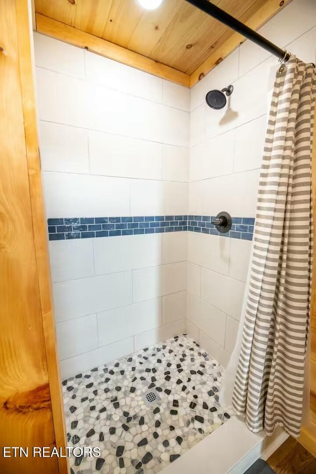 bathroom with wooden ceiling and a shower with curtain