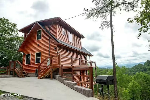 view of property exterior with a wooden deck