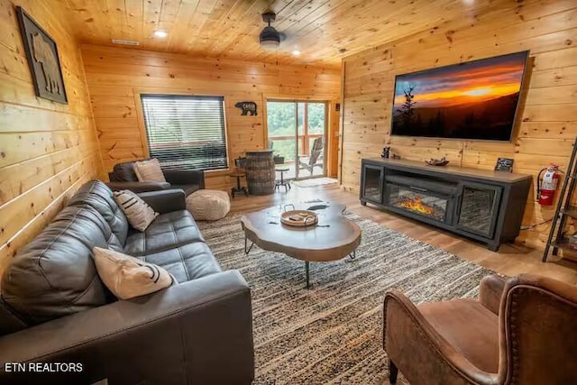 living room with a fireplace, wooden walls, hardwood / wood-style flooring, and wood ceiling