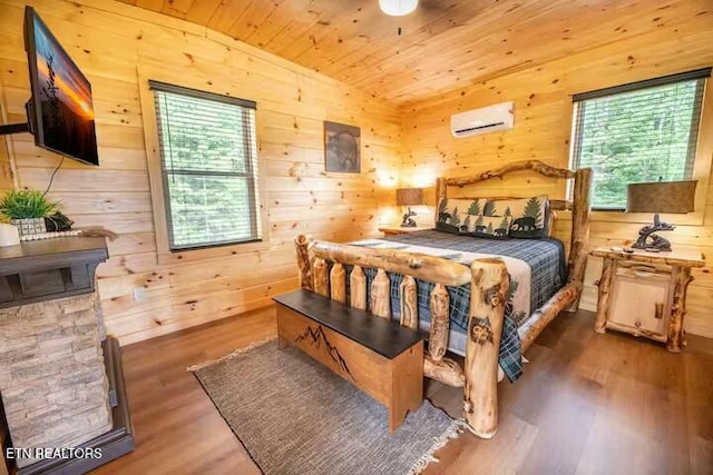 bedroom with an AC wall unit, wood-type flooring, wooden walls, and wooden ceiling