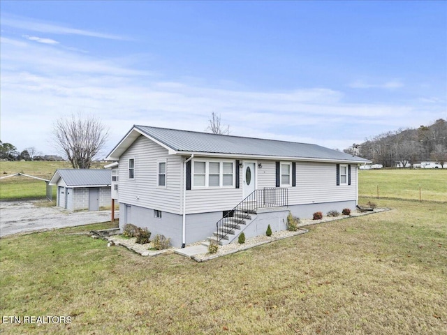 view of front of property with a garage, an outdoor structure, and a front yard