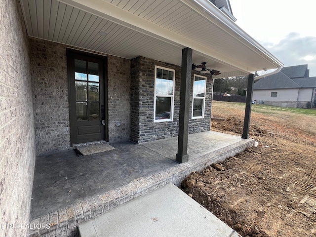 entrance to property with a patio area and ceiling fan