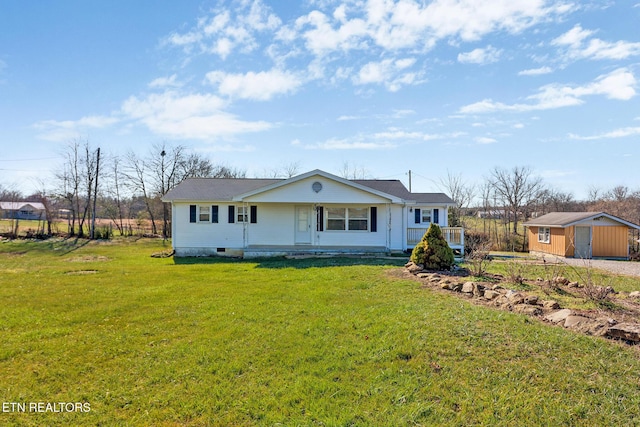 view of front facade with a front lawn, a porch, and a storage shed