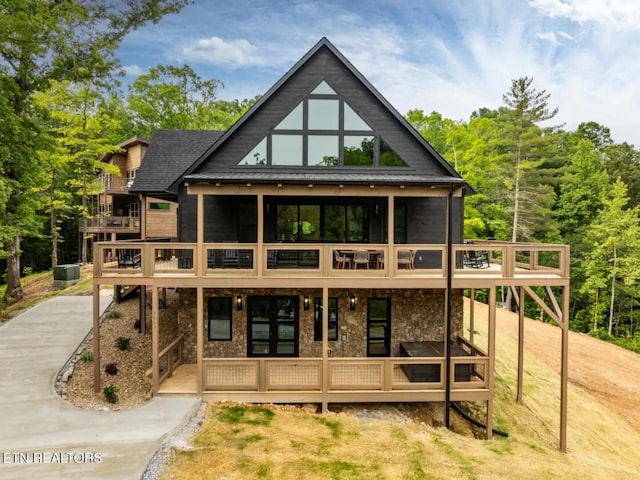 rear view of property featuring a sunroom and a wooden deck