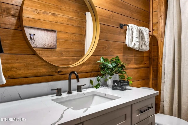 bathroom featuring wooden walls and vanity