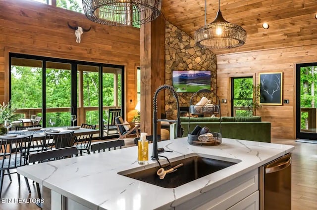 kitchen with a chandelier, decorative light fixtures, a kitchen island with sink, and a healthy amount of sunlight