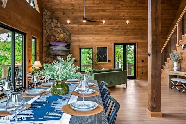 unfurnished dining area featuring hardwood / wood-style flooring, high vaulted ceiling, a wealth of natural light, and wood ceiling