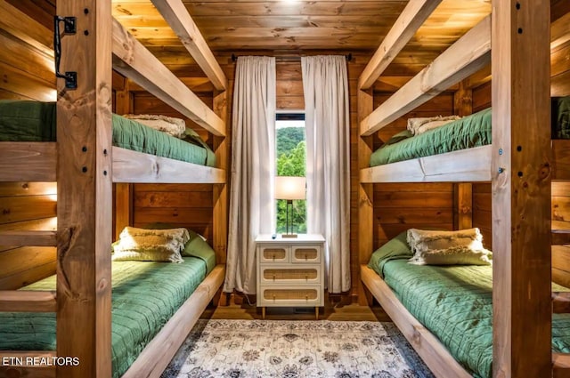 bedroom with beam ceiling, wood-type flooring, and wood ceiling