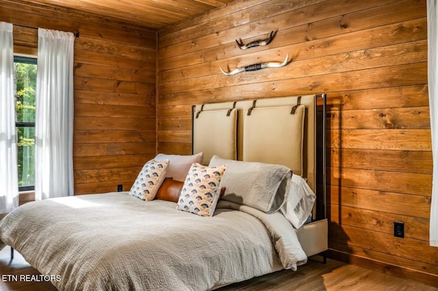 bedroom featuring hardwood / wood-style floors, wooden ceiling, and wooden walls