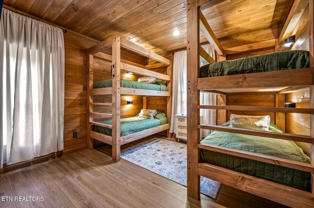 unfurnished bedroom with hardwood / wood-style floors, wooden ceiling, and wood walls