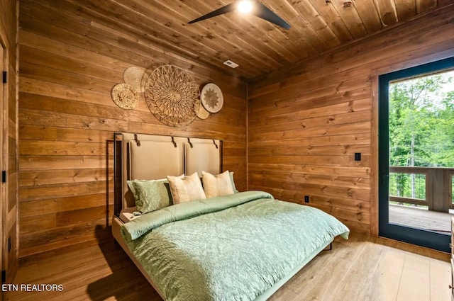 bedroom with hardwood / wood-style floors, ceiling fan, wooden walls, and wood ceiling