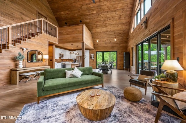 living room with hardwood / wood-style flooring, wood walls, wood ceiling, and high vaulted ceiling