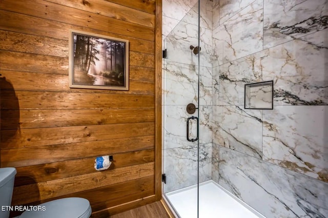 bathroom featuring wood walls, a shower with door, wood-type flooring, and toilet