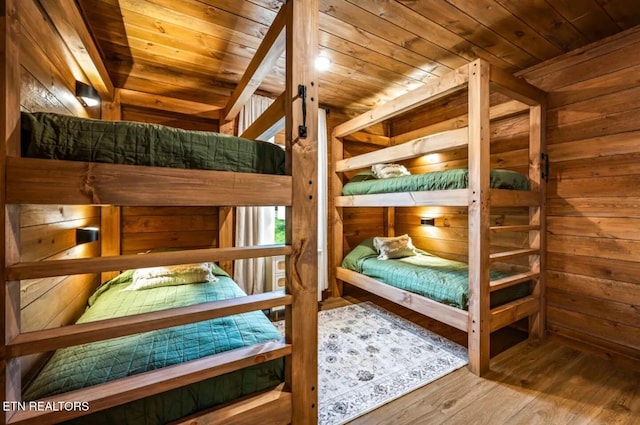 bedroom featuring wood-type flooring, wooden ceiling, and wood walls