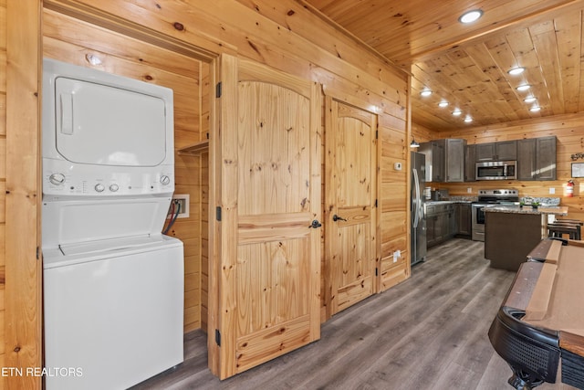 interior space featuring stacked washer and clothes dryer, dark hardwood / wood-style flooring, wood walls, and wood ceiling