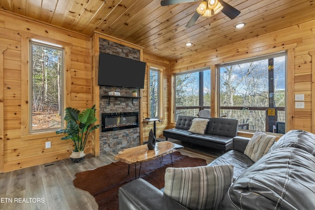 living room featuring a wealth of natural light, wood walls, wooden ceiling, and hardwood / wood-style floors