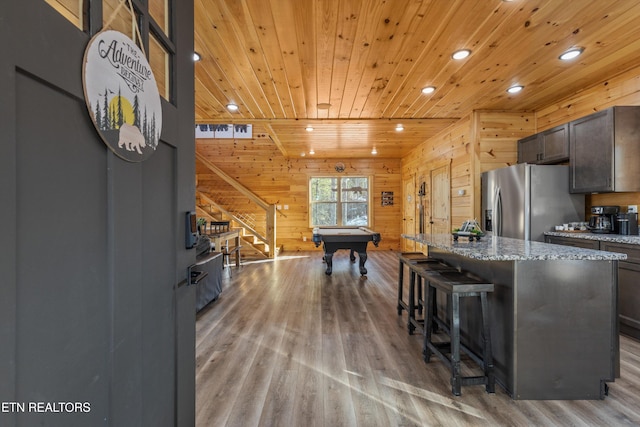 kitchen with billiards, a center island, wood ceiling, stainless steel refrigerator with ice dispenser, and dark brown cabinets