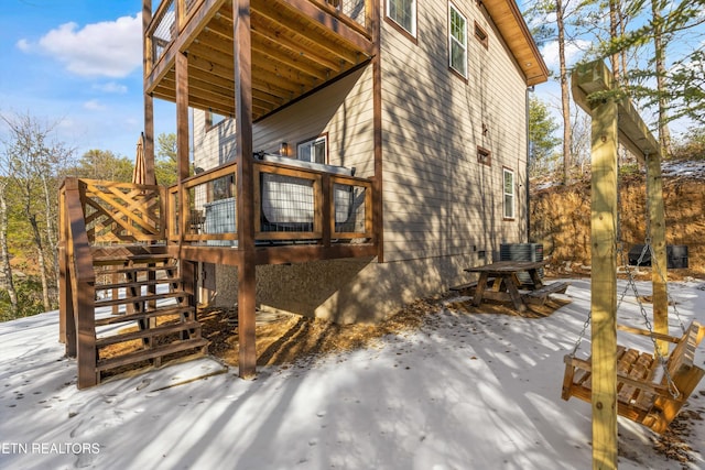 view of snow covered exterior with a wooden deck