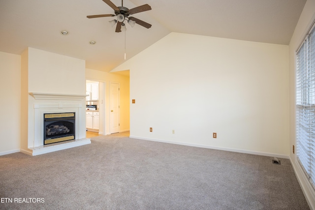 unfurnished living room with ceiling fan, light colored carpet, and vaulted ceiling