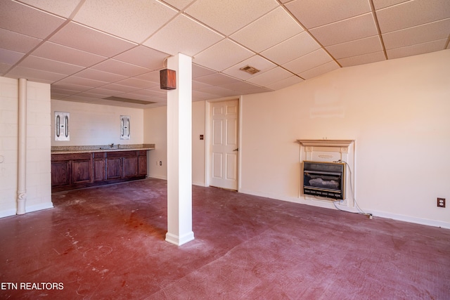 basement featuring dark colored carpet, heating unit, and sink