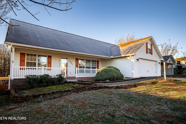 view of front of home with a porch, a garage, and a front lawn