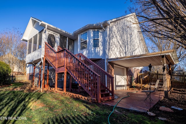 back of property featuring a sunroom, a garage, and a patio area