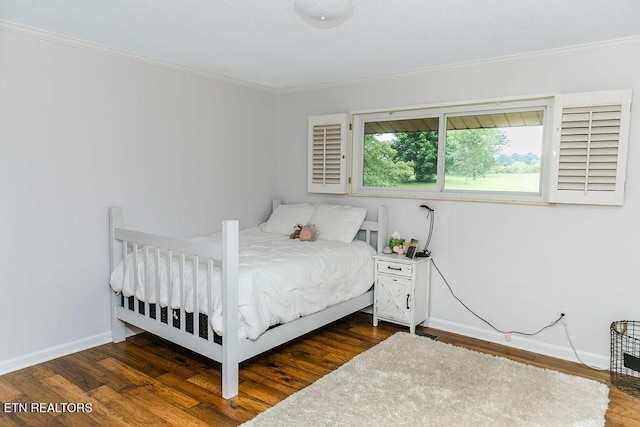 bedroom with dark hardwood / wood-style flooring and ornamental molding