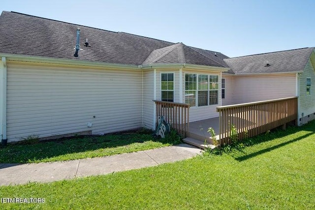 rear view of house with a lawn and a wooden deck