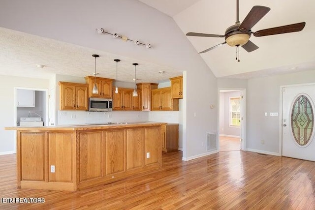 kitchen with ceiling fan, light hardwood / wood-style flooring, pendant lighting, and vaulted ceiling