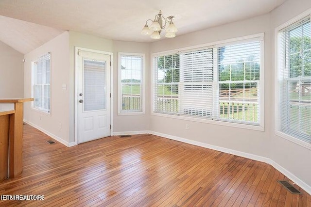 unfurnished dining area featuring hardwood / wood-style floors and a notable chandelier