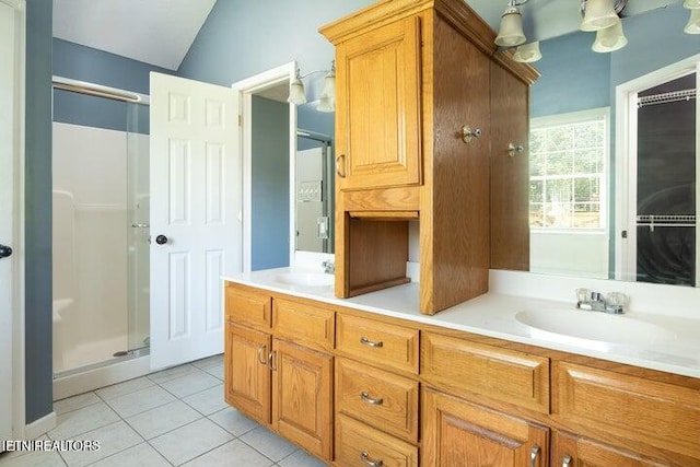 bathroom featuring tile patterned floors, vanity, a shower with shower door, and vaulted ceiling