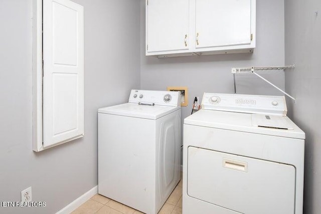 clothes washing area with cabinets, light tile patterned floors, and separate washer and dryer