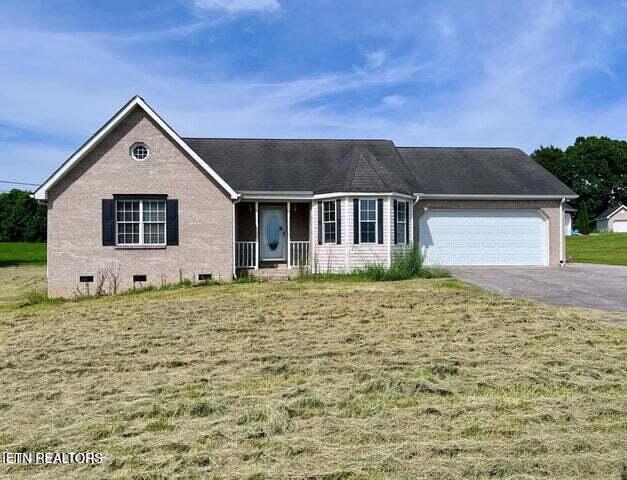 view of front of house with a front yard and a garage