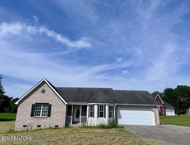 view of front of property with a front yard and a garage