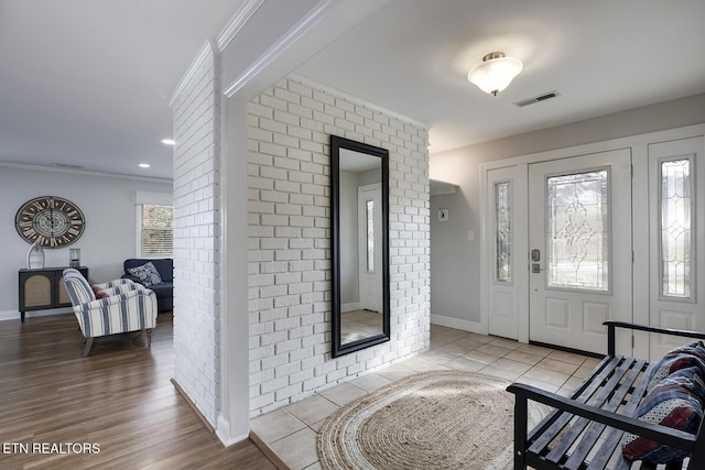 foyer featuring ornamental molding and light tile patterned floors