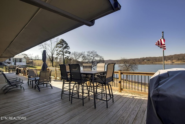 wooden terrace featuring a grill and a water view