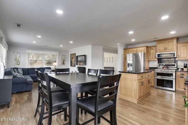 dining space featuring light hardwood / wood-style floors and crown molding