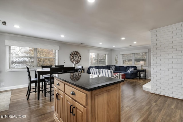 kitchen featuring ornamental molding, dark hardwood / wood-style flooring, and a kitchen island