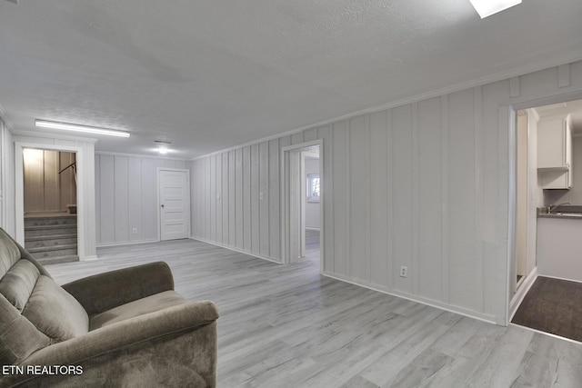 living area featuring light wood-type flooring and ornamental molding