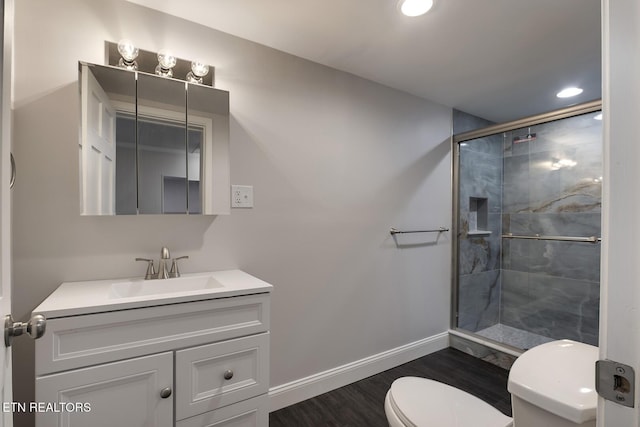 bathroom featuring toilet, vanity, a shower with shower door, and hardwood / wood-style floors