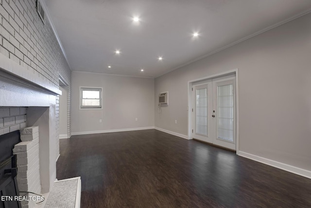 unfurnished living room featuring brick wall, french doors, dark hardwood / wood-style flooring, a fireplace, and ornamental molding