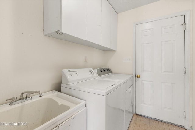 laundry area with sink, washer and dryer, and cabinets